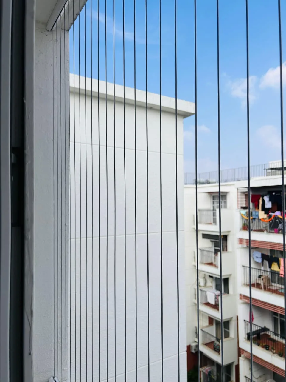 Apartment balcony in Bangalore fitted with invisible grills, overlooking the city