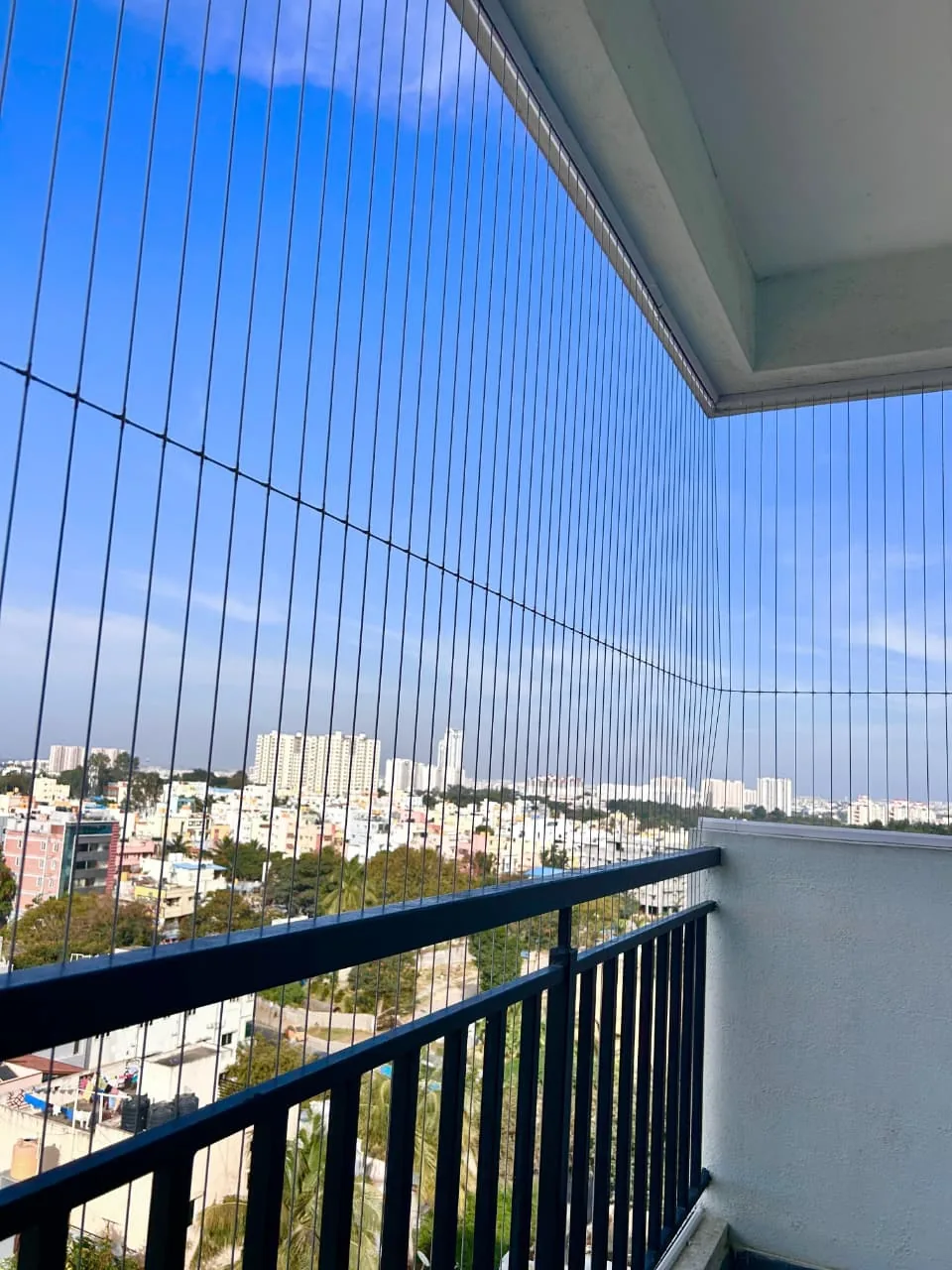 Invisible grill cables along a balcony railing with clear sky view